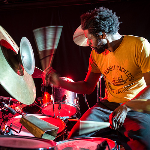 Photo of man playing the drums, not looking at the camera (Marshall R. Trammell)
