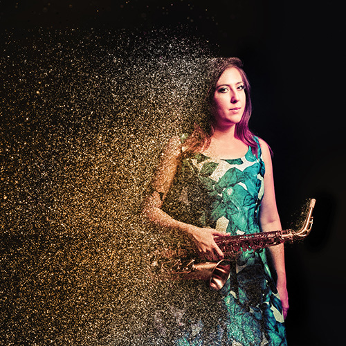 Photo of woman looking at the camera, holding a saxophone (Olivia Shortt)