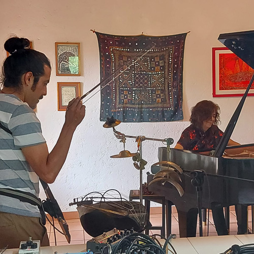 photo of two artist playing instrucments in a decorated room (Ana Ruiz, Mauricio Sotelo)