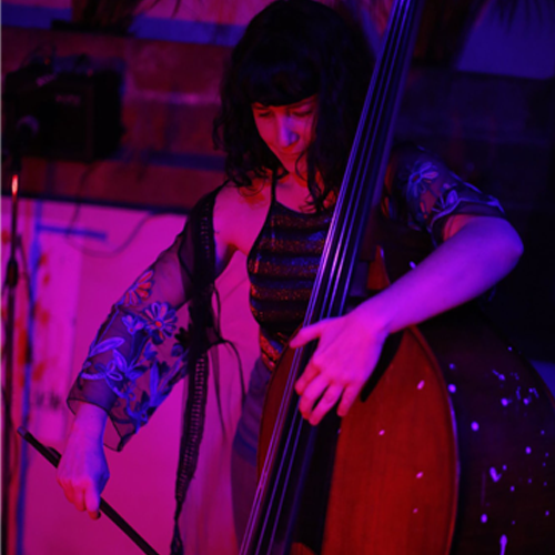 An image of Adriana Camacho playing an upright bass with a bow.